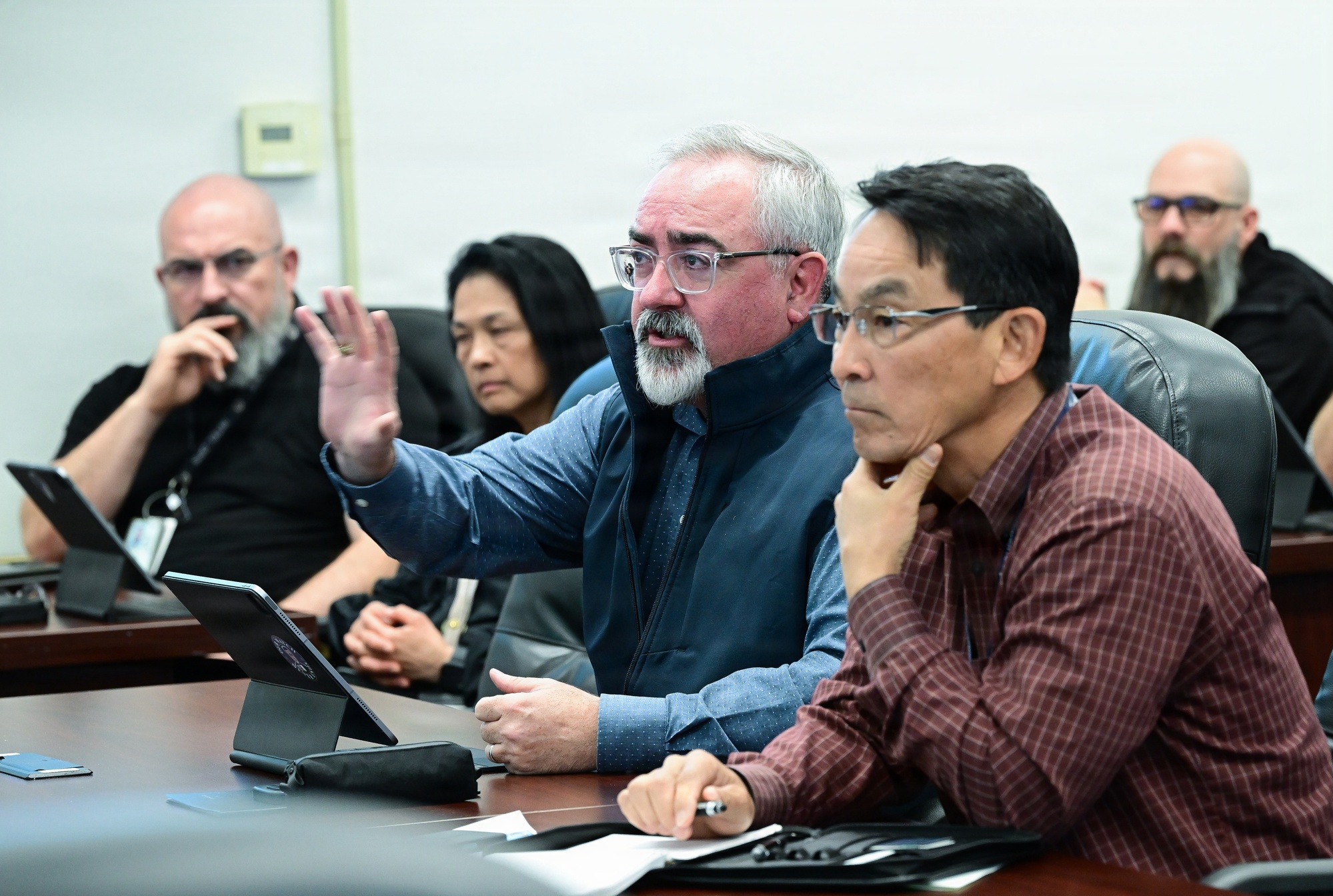 Naval Surface Warfare Center officials listen and ask questions during a consortium meeting.